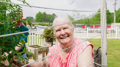 Resident gardening in a sunny outdoor space