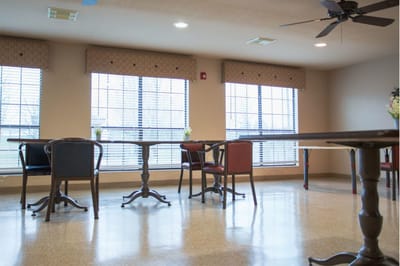 A well-lit common area with tables and chairs