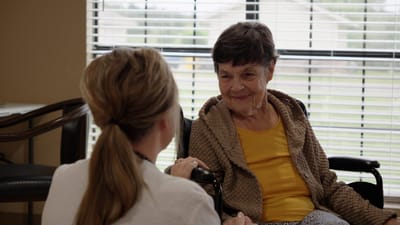 Resident interacting with staff in a cozy lounge