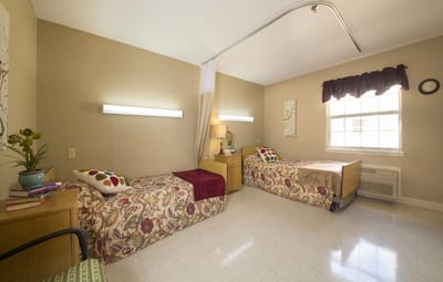 A cozy interior room with two beds and natural light
