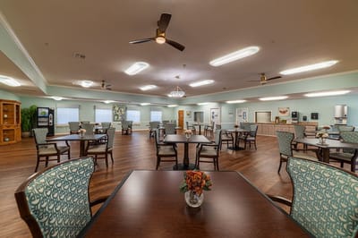 Bright dining room with tables and chairs set up