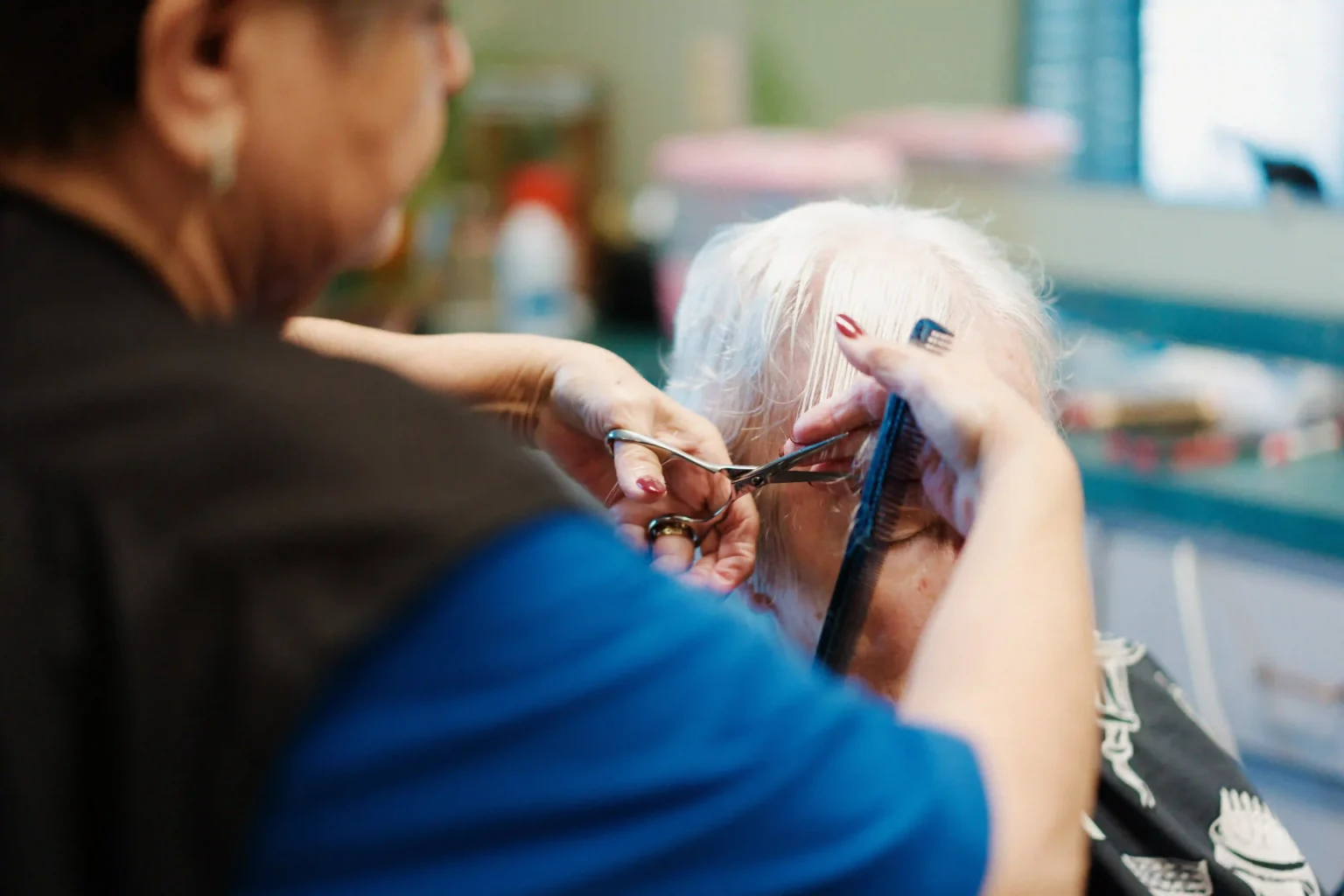 Hair stylist giving a haircut to a resident
