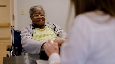Resident receiving care from staff in a facility