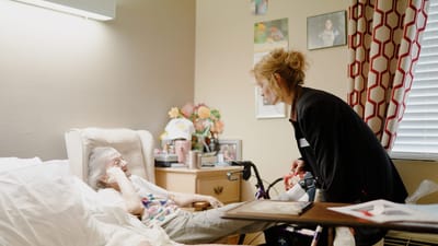 Caregiver assisting a resident in their room