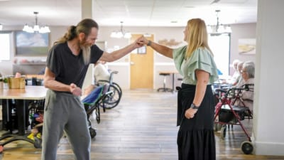 Residents dancing with a staff member in a common area