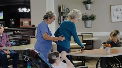 Staff assisting residents in an activity room