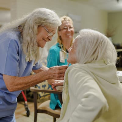 Staff interacting warmly with residents in a cozy setting
