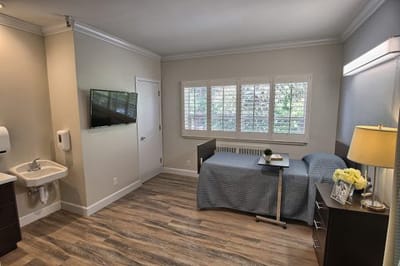 Comfortable room with a bed, table, and TV