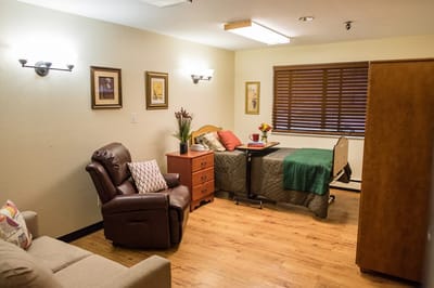 Cozy interior view of a resident's room with bed and chair