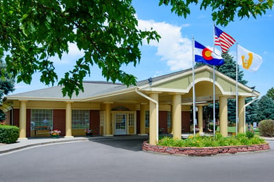 Front entrance of a senior living facility with flags