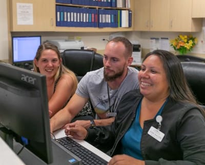 Staff assisting residents at a computer station