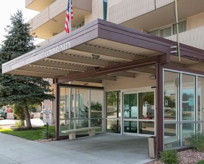 Entrance of a senior living facility with flag