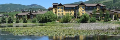 Exterior view of a senior living facility by a lake