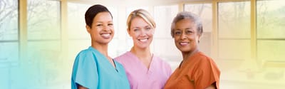 Three healthcare workers smiling in a facility