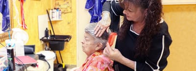 A stylist giving a haircut to a resident