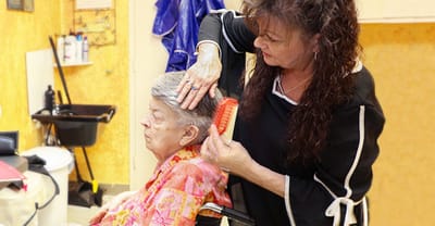 A resident receiving a hair salon service