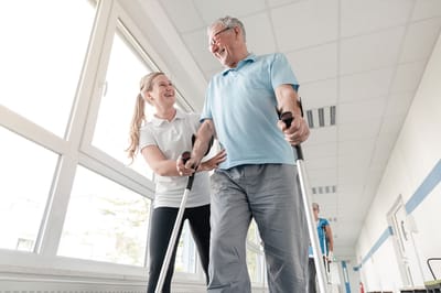 A caregiver assisting a resident in a hallway