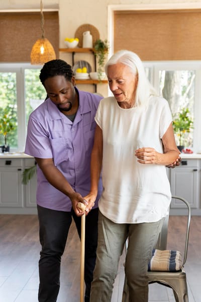 Caregiver assisting a senior woman in a bright room