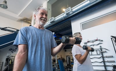 Seniors exercising with weights in a gym