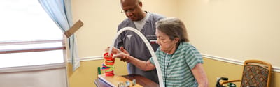 Staff member assisting a resident with an activity