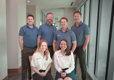 Staff members posing together in a facility hallway