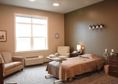 A private resident room with a bed and seating