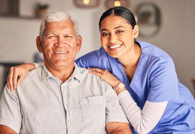 A smiling resident and caregiver in a facility