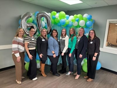 Staff members celebrating a milestone with balloon decorations