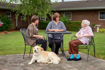 Residents and staff enjoying time outdoors with a dog