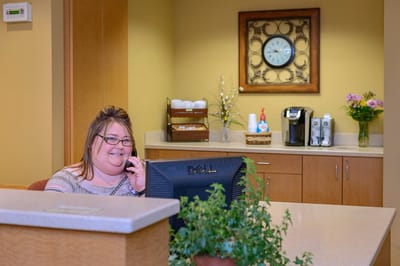 Receptionist at a brightly lit front desk