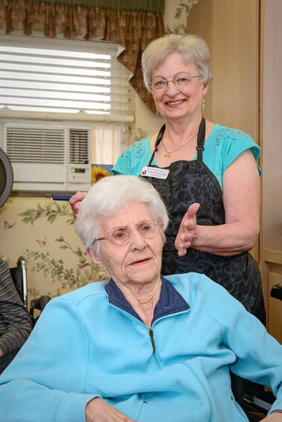 Stylist assisting resident in a cozy salon space