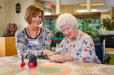 Staff member and resident sharing a moment at a table