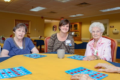 Three residents engaging in a bingo game in a common area