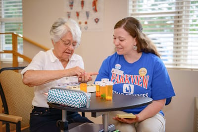 Senior resident engaging in activities with staff member