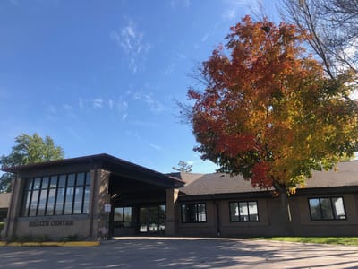 Exterior view of a health center with autumn tree