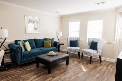 Bright common area with blue couch and chairs