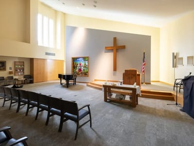 Quiet interior space with a large cross and stained glass