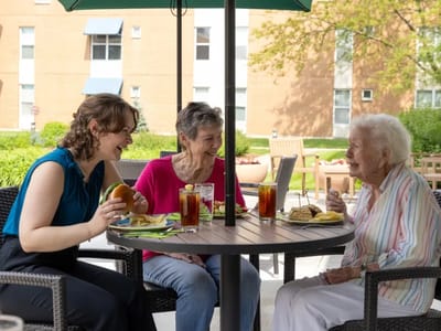 Residents enjoying lunch outside in a social setting