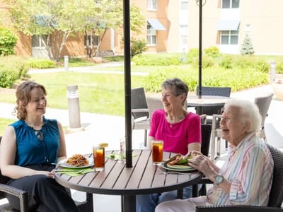 Residents enjoying lunch on a patio with drinks