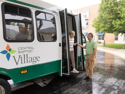 Resident getting assistance from staff near transport vehicle