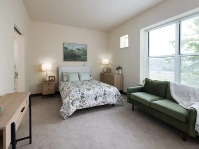 A private resident room with a bed and couch