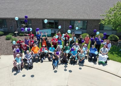 Residents celebrating outdoors with balloons and smiles