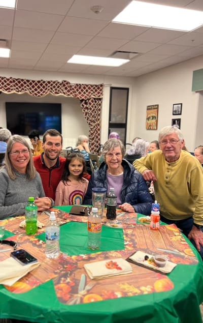 Residents and staff enjoying a meal at a table