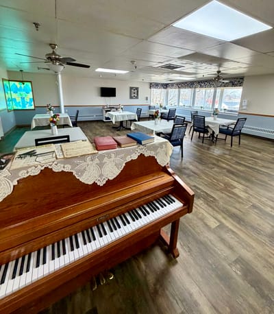 Interior view of a common area with tables and a piano
