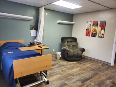A cozy senior living room with a bed and recliner