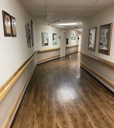 A well-lit corridor with framed art on the walls
