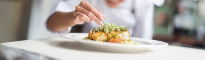 Chef garnishing a plated meal