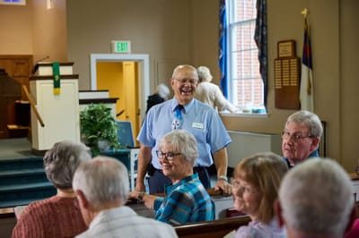 Smiling staff member interacting with residents in a common area