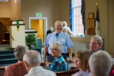 Smiling staff member engaging with elderly residents