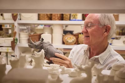 Senior resident holding a decorative ceramic rhinoceros